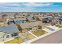 An aerial view showcases a residential neighborhood with well-maintained homes and green spaces on a sunny day at 56375 E 22Nd Pl, Strasburg, CO 80136