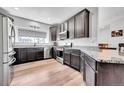 Well-lit kitchen boasts stainless steel appliances, modern countertops, and dark wood cabinets at 56375 E 22Nd Pl, Strasburg, CO 80136