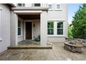 Inviting front porch with decorative stone accents, stylish lighting, and a cozy outdoor fireplace at 15377 W Iliff Dr, Denver, CO 80228