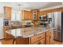Spacious kitchen with granite countertops, stainless steel appliances, and custom cabinets at 13106 W Chenango Ave, Morrison, CO 80465