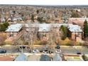 Aerial view of a brick apartment complex surrounded by mature trees in a residential neighborhood at 3249 W Fairview Pl # 207, Denver, CO 80211