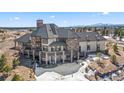 Back of luxury home with stone accents, a deck, multiple windows, and a picturesque mountain view at 19205 Sixpenny Ln, Monument, CO 80132