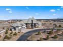 Expansive home featuring a grand entrance, mature trees, and a long driveway, set against a scenic backdrop at 19205 Sixpenny Ln, Monument, CO 80132