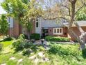 Charming brick home with well-manicured lawn, mature trees, and stone walkway leading to the front door at 2552 E Alameda Ave # 16, Denver, CO 80209