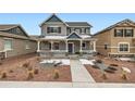 Charming two-story home with gray stucco, white trim, covered porch, and beautifully landscaped front yard at 668 Sage Forest Ln, Monument, CO 80132