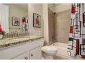 Cozy full bathroom featuring tiled shower, granite counter tops, and unique artwork at 6630 S Coolidge Ct, Aurora, CO 80016