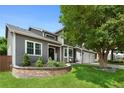 View of home featuring attached three-car garage and lush landscaping at 7027 Chestnut Hill St, Highlands Ranch, CO 80130