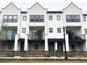 Exterior of a townhome with a balcony, a wooden fence, and a green lawn at 8311 Parkland St, Broomfield, CO 80021
