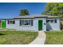 Charming single-story home with a green door, well-manicured lawn, and blue sky overhead at 9411 Rose Ct, Thornton, CO 80229