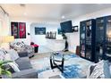 Open living room featuring neutral walls, cozy couches, modern lighting, and stylish decor at 9411 Rose Ct, Thornton, CO 80229