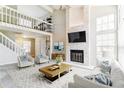 Two-story living room featuring a stone fireplace, vaulted ceiling, and abundant natural light at 1550 S Syracuse St, Denver, CO 80231