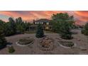 A beautifully landscaped home illuminated by a vibrant sunset at 9353 E 146Th Ave, Brighton, CO 80602