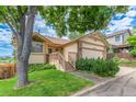 Beautiful home featuring a manicured lawn, inviting front porch with wood accents and a two-car garage at 10478 W 82Nd Ave, Arvada, CO 80005