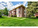 Exterior angle of the condo featuring brick and siding, balconies, and green lawn space at 12132 Huron St # 203, Denver, CO 80234