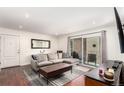 Cozy living room with hardwood floors, neutral-toned couch, and a sliding door to the balcony at 12132 Huron St # 203, Denver, CO 80234