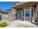 Charming entryway with stone pillars, covered porch, and stylish front door at 4887 Raven Run, Broomfield, CO 80023