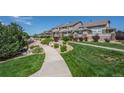 Well-manicured lawn and landscaped walkway leading to townhomes in a tranquil community at 4887 Raven Run, Broomfield, CO 80023