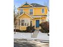 Two-story yellow house with blue door, snowy front yard, charming details at 1503 S Buckley Way, Aurora, CO 80017