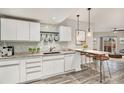 Modern kitchen featuring white cabinets, granite counters, and breakfast bar at 8757 E Dry Creek Rd # 1512, Englewood, CO 80112