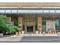 Stone building entrance featuring 'The Landmark West' sign, decorative potted plants, and a comfortable bench at 5455 Landmark Pl # 1414, Greenwood Village, CO 80111