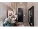 Entry foyer with decorative wall art, mirror, dark wood door, and light-colored walls at 5455 Landmark Pl # 1414, Greenwood Village, CO 80111