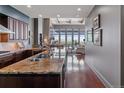 Modern kitchen with granite countertops, stainless steel appliances, and hardwood floors leading to a living area at 5455 Landmark Pl # 1414, Greenwood Village, CO 80111