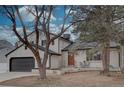 Charming two-story home featuring a brick exterior, a well-manicured lawn, and a two-car garage at 7249 S Iris Ct, Littleton, CO 80128