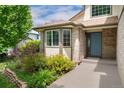 Close up shot of the home's entryway with brickwork, a bay window, and a garden with lush landscaping at 11335 W 54Th Ln, Arvada, CO 80002
