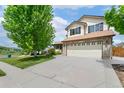Inviting two-story home featuring a well-maintained lawn and a spacious driveway leading to a two-car garage at 11335 W 54Th Ln, Arvada, CO 80002