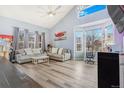 Bright living room featuring vaulted ceilings, large windows, and modern gray flooring at 16160 E 119Th Ave, Commerce City, CO 80022