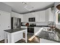 Bright kitchen featuring stainless steel appliances, granite counters, and white cabinetry at 2432 S Genoa Way, Aurora, CO 80013