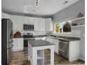 Modern kitchen with white cabinets, granite countertops, stainless steel appliances, and an island at 2432 S Genoa Way, Aurora, CO 80013
