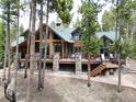 An expansive deck with stone pillars offers panoramic views of the surrounding forest at 47 Forest Cir, Breckenridge, CO 80424