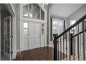 Bright foyer featuring a soaring ceiling, a grand staircase, and elegant entry door at 47032 Frasier Fir Cir, Parker, CO 80138