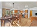 Eat-in kitchen with wood cabinets, stainless appliances, and a sun-filled dining area at 11953 Us Highway 285, Conifer, CO 80433
