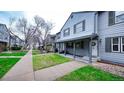 Charming townhome exterior with well-maintained lawn, sidewalk, and covered front porch at 677 Vrain St # 15, Denver, CO 80204