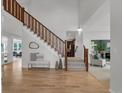 Bright foyer with hardwood floors, a staircase, and an open view to other living spaces at 10683 Amesbury Way, Highlands Ranch, CO 80126