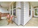 Inviting front porch featuring a seating area, ample windows, and brick accents at 10683 Amesbury Way, Highlands Ranch, CO 80126