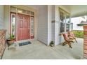 Charming front porch with seating, a red door, and a HOME welcome mat at 10683 Amesbury Way, Highlands Ranch, CO 80126