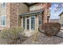 Cozy enclosed front porch with stone accents and mature landscaping at 2824 W Centennial Dr # L, Littleton, CO 80123