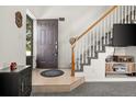 Inviting entryway boasts tile flooring, a staircase with white spindles, and access to the main living areas at 4713 Perth St, Denver, CO 80249