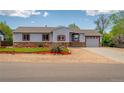 Single story home features stone accents, a well-maintained lawn, and fresh landscaping at 1035 Quartz St, Golden, CO 80401