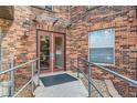 Building entrance with double doors, brick facade, and accessibility ramp at 9019 E Panorama Cir # D207, Englewood, CO 80112