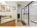 Modern bathroom featuring a walk-in shower with sleek glass doors, granite countertops, and contemporary fixtures at 6534 S Union Way, Littleton, CO 80127