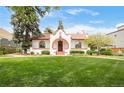 Inviting home exterior with a large green lawn, mature trees, and a red brick accented facade at 2715 W 37Th Ave, Denver, CO 80211