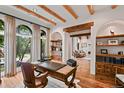 Charming home office with wood beams, hardwood floors, and a large arched window at 458 Adams St, Denver, CO 80206