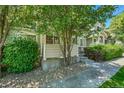 Charming home featuring a covered front entrance with decorative shrubs and a stone covered yard at 4006 E Geddes Cir, Centennial, CO 80122