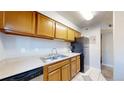 Kitchen featuring light wood cabinets, black appliances, and a double stainless sink at 12360 W Nevada Pl # 101, Lakewood, CO 80228
