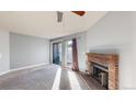 Well-lit living room featuring a brick fireplace and sliding doors to the outside at 12360 W Nevada Pl # 101, Lakewood, CO 80228