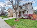 Inviting two-story home with a covered porch, well-maintained lawn, and landscaped front yard at 9774 Burberry Way, Highlands Ranch, CO 80129